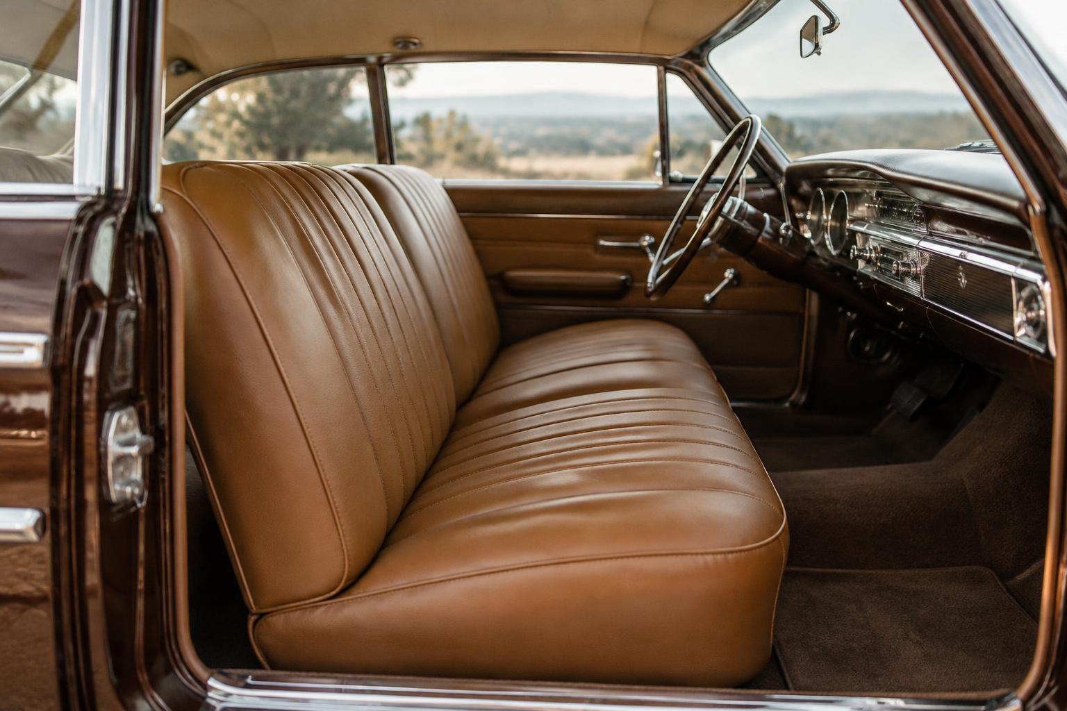 Tan leather bench seat in a vintage car interior
